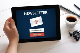 Hand holding digital tablet computer with subscribe newsletter c