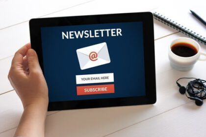 Hand holding digital tablet computer with subscribe newsletter c